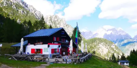 Rifugio Antelao, con le sue persiane rosse, accoglie i visitatori anche in ottobre, immerso in un paesaggio alpino mozzafiato.