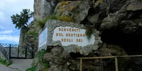 Ingresso del Sentiero degli Dei, con cartello di benvenuto e cancello in ferro battuto.