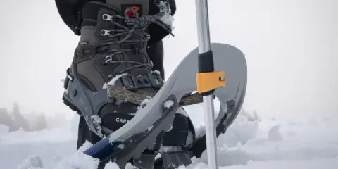 Scarponi e racchette da neve pronti per una ciaspolata sulla neve fresca.