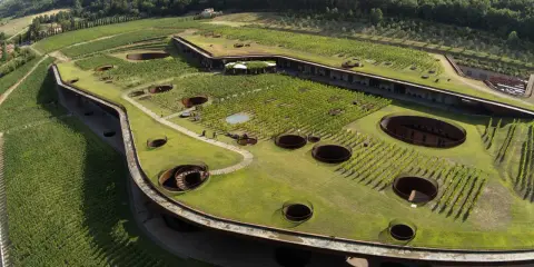Cantine da visitare in Toscana: un'architettura unica che si fonde con i vigneti, con pozzi circolari che conducono al sottosuolo.