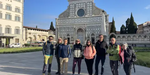 Un gruppo di escursionisti posa davanti alla Basilica di Santa Maria Novella, un'icona lungo la Via Romea Sanese.