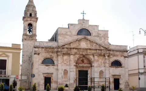La Cattedrale di San Michele Arcangelo a Sammichele di Bari, con il suo imponente campanile e la facciata in pietra chiara, domina la piazza.