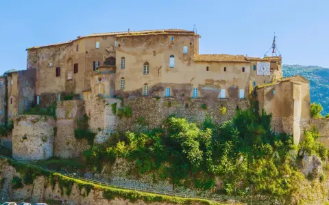Antico castello su una collina, uno dei borghi medievali vicino Roma, con un grande orologio sulla torre.