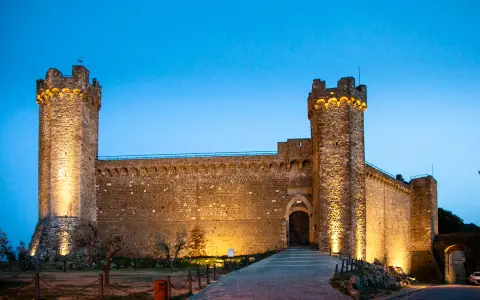 La Fortezza di Montalcino, illuminata di sera, è un must per chi visita Montalcino cosa vedere in un giorno.