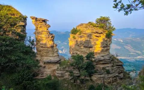 Formazioni rocciose suggestive illuminate dal sole, un paesaggio mozzafiato che ricorda le tappe del cammino della Via degli Dei.