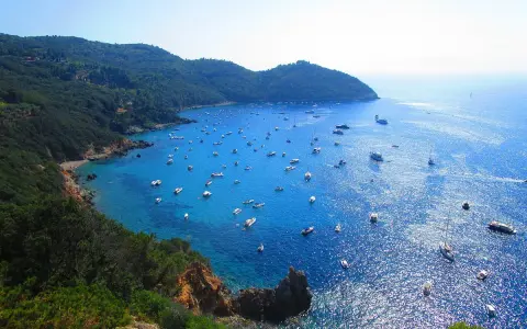 Cala Grande Argentario: un paradiso azzurro con barche. Per arrivare, goditi questo panorama mozzafiato.