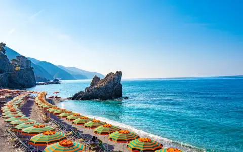 Spiaggia con ombrelloni colorati e mare cristallino, un angolo di paradiso, il mare più vicino a Milano.