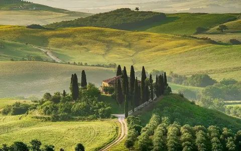Colline toscane con cipressi e casale, un'immagine iconica dei borghi da visitare in Toscana.