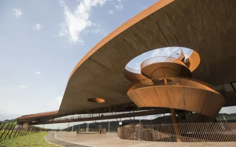 Architettura moderna di cantine toscana famose, con scale a chiocciola in corten e ampie vetrate che riflettono il paesaggio collinare.