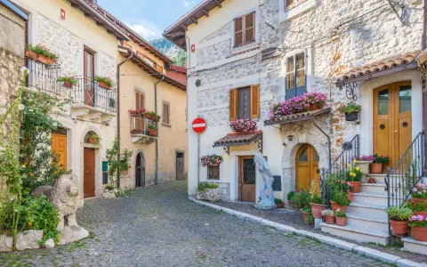 Antica via acciottolata tra **borghi Abruzzo sul mare**, con case in pietra e fiori colorati sui balconi.