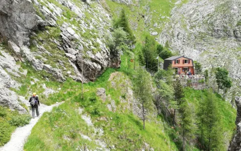 Escursionista sul sentiero della via Vandelli, con rifugio in vista.