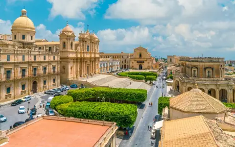 Vista aerea di un noto borgo della costiera amalfitana, con chiese barocche, piazze e strade animate.