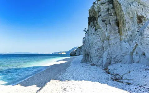 Scogliera bianca a picco sul mare cristallino, un angolo di paradiso tra le spiagge più belle dell'Isola d'Elba.