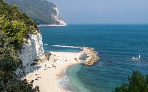 Spiaggia dorata con scogliere bianche e mare cristallino, un angolo di paradiso tra le migliori spiagge del nord Italia.