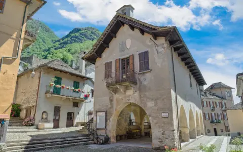 Un borgo antico con case in pietra e balconi fioriti, incastonato tra montagne verdi. Un luogo che fa venire vogogna cosa vedere, per la sua bellezza autentica.