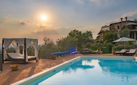 Piscina e lettini in una delle splendide tenute in Toscana al tramonto.