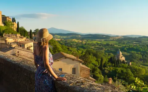 Donna con cappello ammira il panorama collinare toscano, perfetto per scoprire cosa visitare in Toscana in 2 giorni.