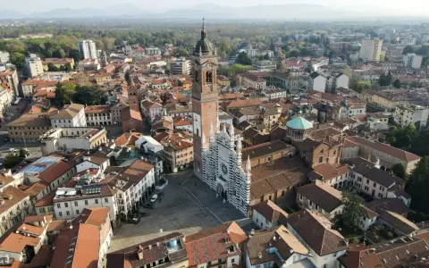 Vista aerea della Duomo di Monza, con la sua facciata a strisce bianche e nere. Si vede il campanile e il centro storico, che mostra dove si trova Monza.