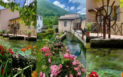 Borghi vicino Foligno: un ruscello attraversa un villaggio con mulini ad acqua, case antiche e fiori colorati.
