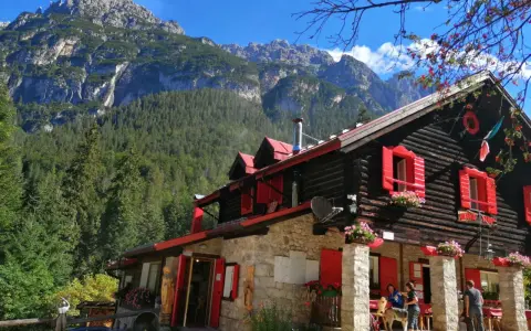Rifugio con forni di sopra, circondato da boschi e montagne imponenti.