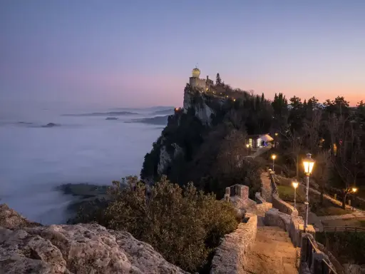 Torre Guaita domina la nebbia al tramonto, un luogo magico dove si trova San Marino.