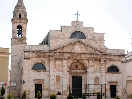 La Cattedrale di San Michele Arcangelo a Sammichele di Bari, con il suo imponente campanile e la facciata in pietra chiara, domina la piazza.