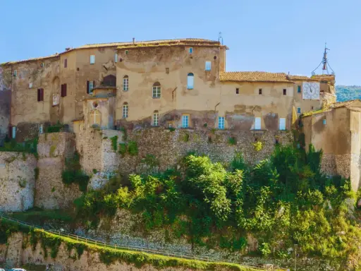 Antico castello su una collina, uno dei borghi medievali vicino Roma, con un grande orologio sulla torre.