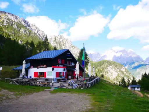 Rifugio Antelao, con le sue persiane rosse, accoglie i visitatori anche in ottobre, immerso in un paesaggio alpino mozzafiato.