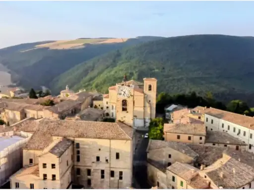 Borgo con torre dell'orologio, immerso nel verde delle colline. Chissà se è questo il borgo dei borghi vincitore.