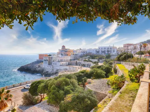 La Maddalena: cosa vedere in un giorno. Panoramica della costa con edifici bianchi e mare blu, un itinerario perfetto per una giornata.
