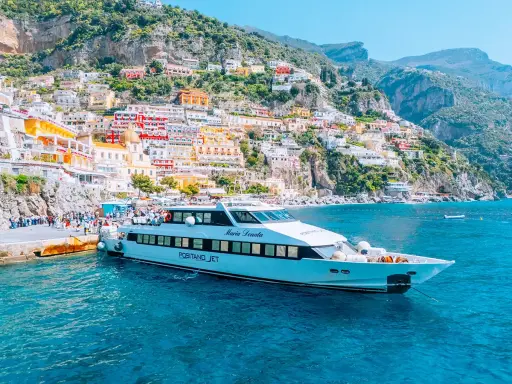 Il Positano Jet attracca al molo, con le case colorate della Costiera Amalfitana sullo sfondo.