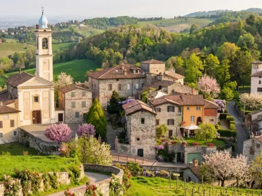 Borgo pittoresco con chiesa e campanile, colline verdi e fiori in primavera. Un luogo incantevole per scoprire cosa vedere a Golferenzo.