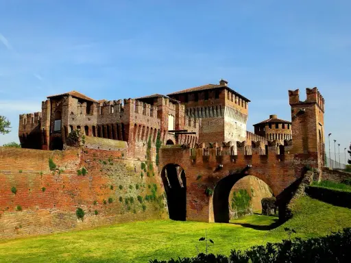 Castello Sforzesco, uno dei borghi belli vicino Cremona, con mura in mattoni rossi, ponti ad arco e fossato verde.