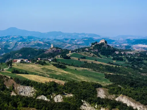 Paesaggio collinare con borghi e torri, ideale per esplorare i sentieri dell'Appennino Tosco Emiliano.