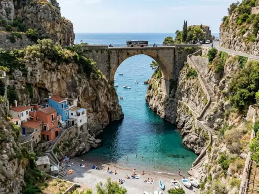 Un ponte ad arco domina un fiordo con case colorate aggrappate alla roccia. Il **furore costiera amalfitana** è un incanto tra mare turchese e sentieri scoscesi.