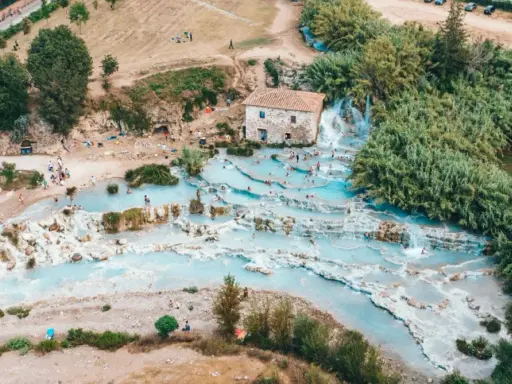 Una perfetta gita domenicale toscana: cascate termali azzurre e gente che si rilassa tra le rocce.