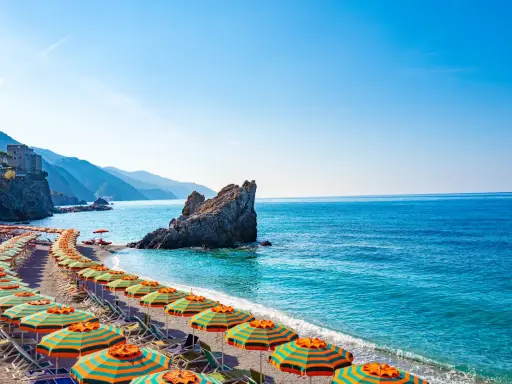 Spiaggia con ombrelloni colorati e mare cristallino, un angolo di paradiso, il mare più vicino a Milano.