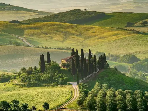 Colline toscane con cipressi e casale, un'immagine iconica dei borghi da visitare in Toscana.
