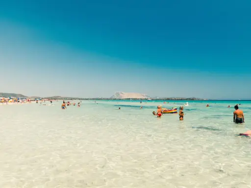 Acque cristalline e gente felice in spiaggia, forse qual è la parte più bella della Sardegna? Un paradiso azzurro.