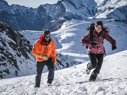 Coppia in montagna con abbigliamento da neve, godendosi l'estate in un paesaggio innevato.