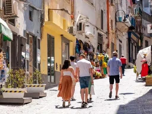 Passeggiata in un vicolo di Procida, tra negozietti colorati e case bianche. Perfetto per capire come muoversi a Procida a piedi.
