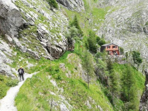 Escursionista sul sentiero della via Vandelli, con rifugio in vista.