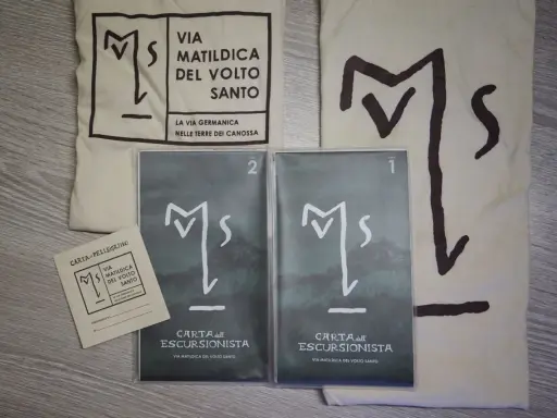 Kit per il pellegrino: sacca, credenziale e due carte dell'escursionista per la Via Matildica del Volto Santo.