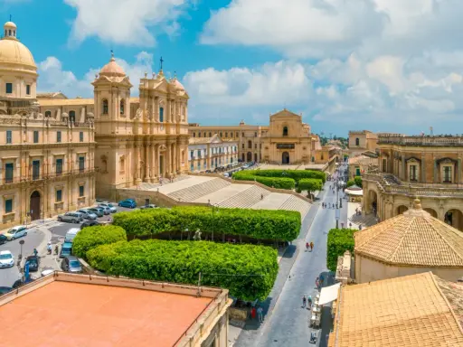 Vista aerea di un noto borgo della costiera amalfitana, con chiese barocche, piazze e strade animate.
