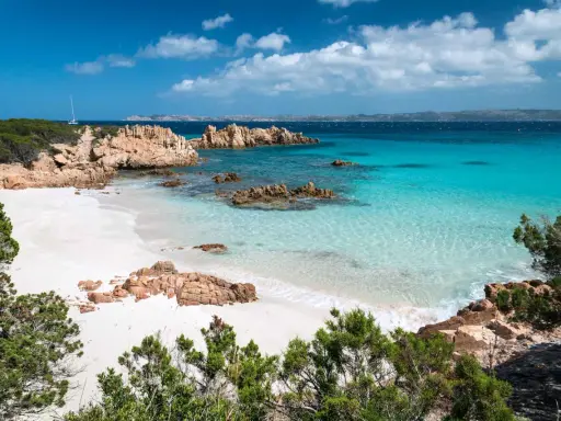 Spiaggia bianca, rocce rosse e mare cristallino: un sogno per chi cerca dove andare al mare a settembre spendendo poco.