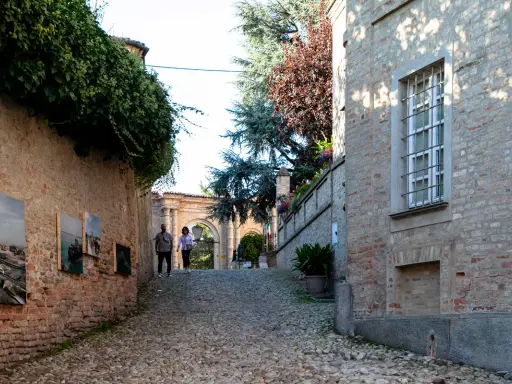 Passeggiata nel centro storico di Neive, tra antiche mura ricoperte d'edera e opere d'arte esposte all'aperto.