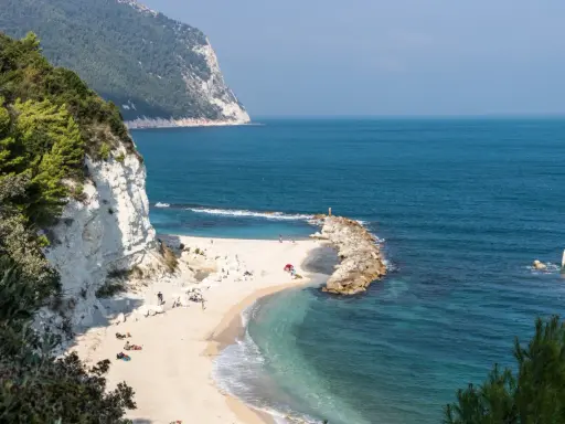 Spiaggia dorata con scogliere bianche e mare cristallino, un angolo di paradiso tra le migliori spiagge del nord Italia.