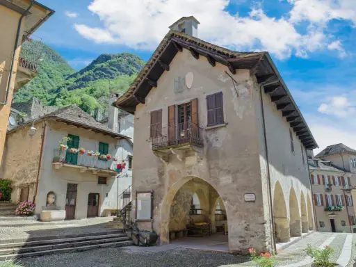 Un borgo antico con case in pietra e balconi fioriti, incastonato tra montagne verdi. Un luogo che fa venire vogogna cosa vedere, per la sua bellezza autentica.