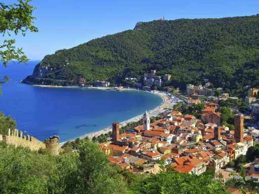 Vista panoramica di pittoreschi liguria paesi sul mare, con case dai tetti rossi che scendono verso una baia azzurra e una spiaggia affollata.