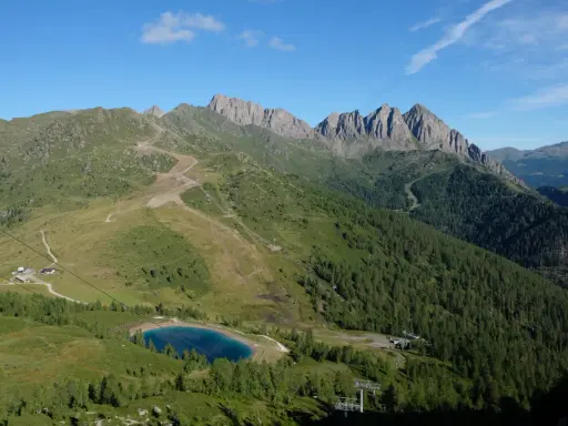 Panorami alpini con sentieri per passeggiate facili vicino a Trento, un lago azzurro e cime rocciose.
